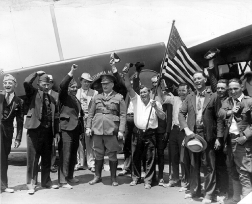 Photo_of_Father_Cox_with_supporters_in_front_of_airplane.