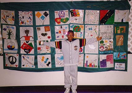 Young man in
front of quilt at '96 conference.